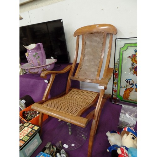 98 - STEAMER CHAIR. POLISHED WOOD WITH CANEWORK SEAT WHICH APPEARS TO BE STRONG AND IN GOOD CONDITION.