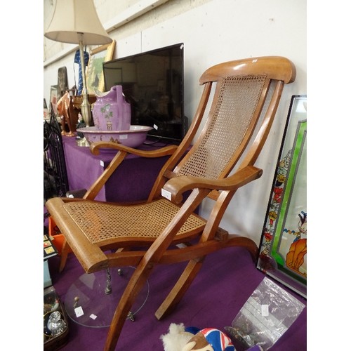 98 - STEAMER CHAIR. POLISHED WOOD WITH CANEWORK SEAT WHICH APPEARS TO BE STRONG AND IN GOOD CONDITION.