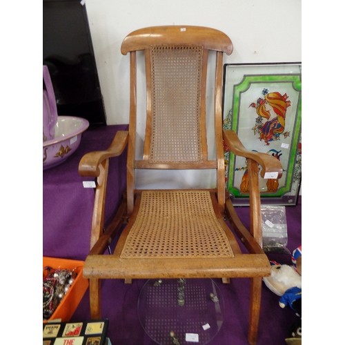 98 - STEAMER CHAIR. POLISHED WOOD WITH CANEWORK SEAT WHICH APPEARS TO BE STRONG AND IN GOOD CONDITION.