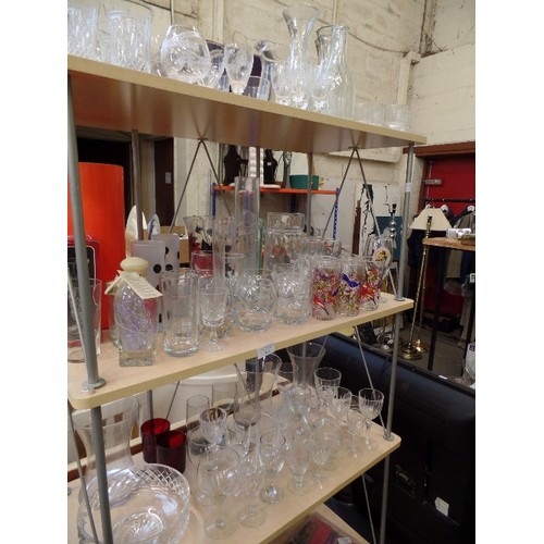 415 - LARGE QUANTITY OF GLASSWARE. 3 SHELVES OF MIXED DRINKING GLASSES, CARAFES, BOWLS, VASES ETC.