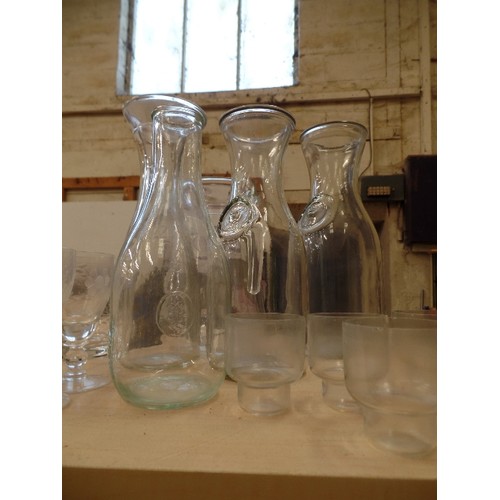 415 - LARGE QUANTITY OF GLASSWARE. 3 SHELVES OF MIXED DRINKING GLASSES, CARAFES, BOWLS, VASES ETC.