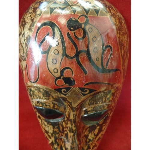 76 - DECORATED AFRICAN WOODEN MASK. LOVELY MUTED COLOURS, RUST, BROWN, BLACK. WALL HUNG. HIGH GLOSS.