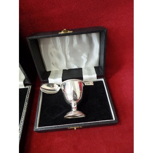 107 - 2 X SILVER-PLATE CHRISTENING EGG-CUP GIFT SETS. ALSO A SET OF TEA-SPOONS. ORIGINAL BOXES.