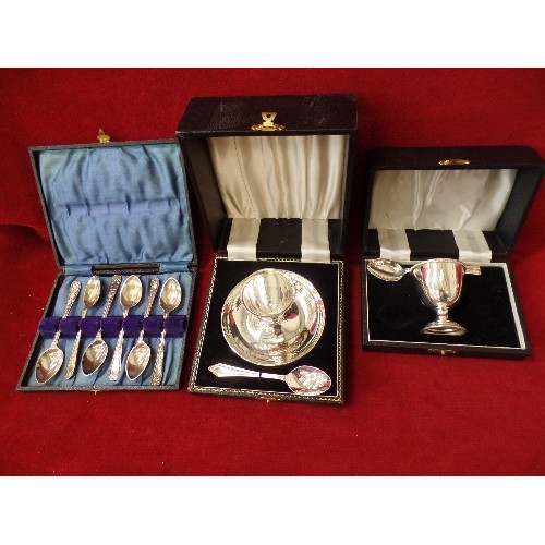 107 - 2 X SILVER-PLATE CHRISTENING EGG-CUP GIFT SETS. ALSO A SET OF TEA-SPOONS. ORIGINAL BOXES.