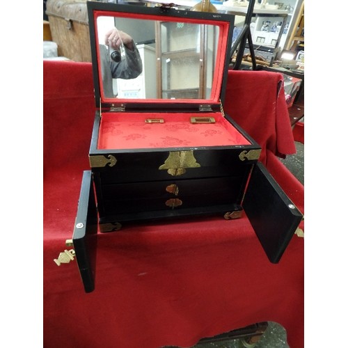 135 - LARGE LAQUERED JEWELLERY CHEST, DECORATED WITH RAISED CHINESE FIGURES/GEISHA. BRASS CORNERS AND CLAS... 