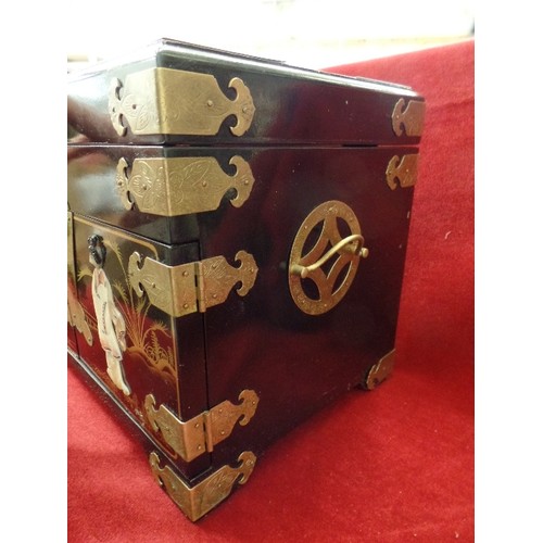 135 - LARGE LAQUERED JEWELLERY CHEST, DECORATED WITH RAISED CHINESE FIGURES/GEISHA. BRASS CORNERS AND CLAS... 