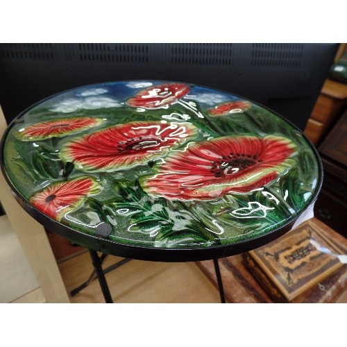 285 - SMALL FOLDING METAL TABLE, WITH LOVELY CIRCULAR GLASS POPPY DESIGN TOP.