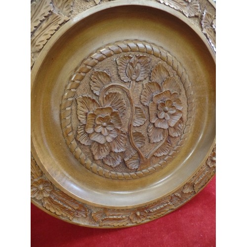 88 - LARGE WOODEN CHARGER PLATE. RAISED CARVED FLOWER DETAIL, HOOK FOR WALL HANGING. 47CM DIAM.