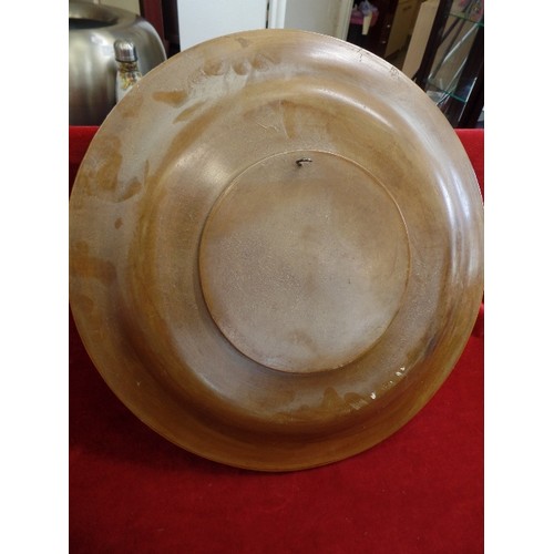 88 - LARGE WOODEN CHARGER PLATE. RAISED CARVED FLOWER DETAIL, HOOK FOR WALL HANGING. 47CM DIAM.