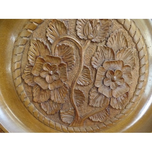 88 - LARGE WOODEN CHARGER PLATE. RAISED CARVED FLOWER DETAIL, HOOK FOR WALL HANGING. 47CM DIAM.