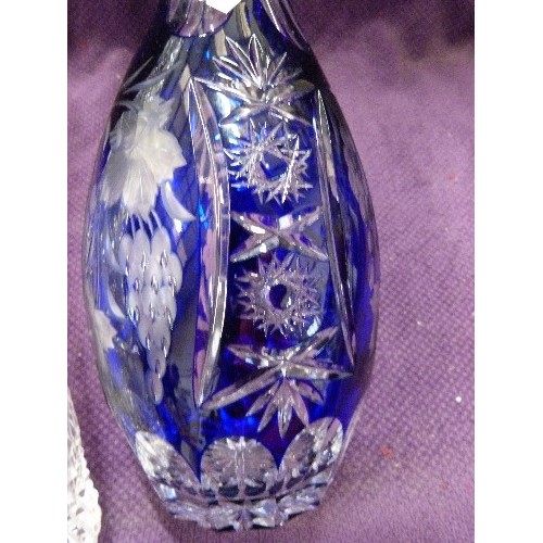 99 - 2 X TALL GLASS DECANTERS. 1 ETCHED IN COBALT BLUE, AND A CUT-GLASS. WITH STOPPERS.