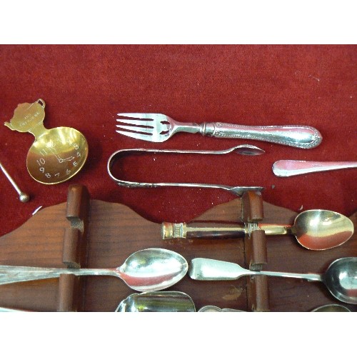 87 - COLLECTABLE VINTAGE SPOONS ON A WOODEN WALL DISPLAY RACK. APPROX 20.