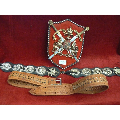 226 - PLASTIC COAT OF ARMS WALL PLAQUE, PLASTIC HORSE BRASSES ON STRAP, AND A LEATHER BELT.