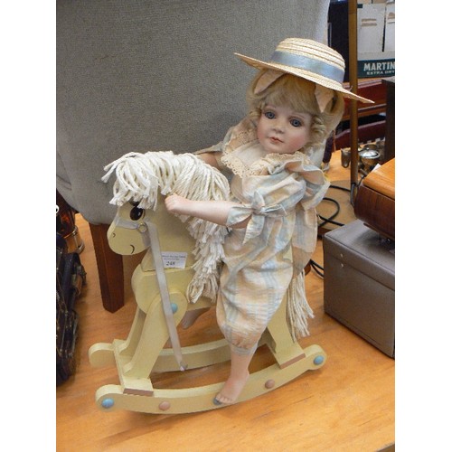 248 - PORCELAIN DOLL ON WOODEN ROCKING HORSE.