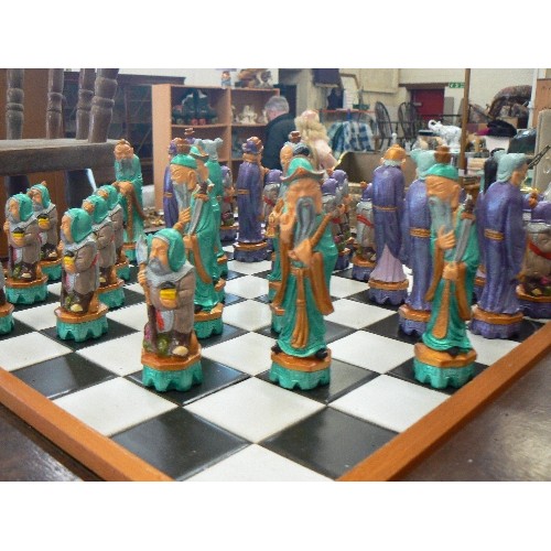 267 - CHESS TABLE WITH 'ORIENTAL FIGURE' CHESS PIECES, WHICH STORE IN THE DRAWER. COUPLE OF SMALL NIBBLES.