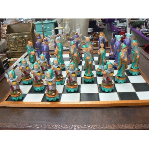 267 - CHESS TABLE WITH 'ORIENTAL FIGURE' CHESS PIECES, WHICH STORE IN THE DRAWER. COUPLE OF SMALL NIBBLES.