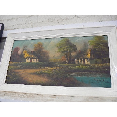 157 - SIGNED OIL ON CANVAS.  THATCHED COTTAGES BY A LAKE. [UNSURE OF ARTIST] IVORY PAINTED FRAME.