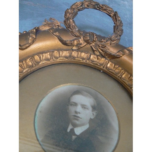 134 - A VICTORIAN CIRCULAR PHOTOGRAPH FRAME IN GILT FINISH WITH A LAUREL WREATH DECORATION - 23CM DIA