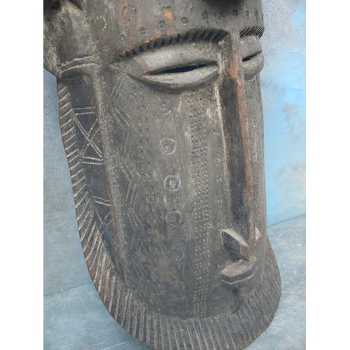 235 - AN AFRICAN CARVED MASK WITH A CROUCHING FIGURE FORMING THE HEADDRESS - PROBABLY FIRST HALF 20TH CENT... 