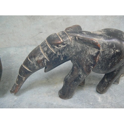 236 - FOUR VINTAGE CARVED ELEPHANT FIGURES INCLUDING AN ADULT AND BABY PULLING / PUSHING A LOG