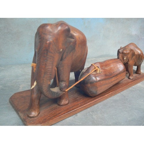 236 - FOUR VINTAGE CARVED ELEPHANT FIGURES INCLUDING AN ADULT AND BABY PULLING / PUSHING A LOG