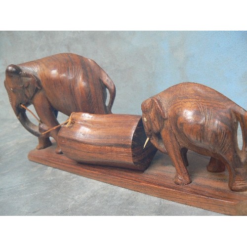 236 - FOUR VINTAGE CARVED ELEPHANT FIGURES INCLUDING AN ADULT AND BABY PULLING / PUSHING A LOG