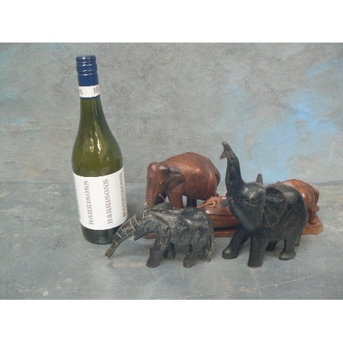 236 - FOUR VINTAGE CARVED ELEPHANT FIGURES INCLUDING AN ADULT AND BABY PULLING / PUSHING A LOG