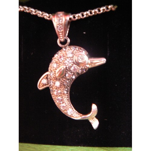 115 - A HEAVY SOLID SILVER DOLPHIN PENDANT ADORNED WITH WHITE STONES ON A SILVER 20