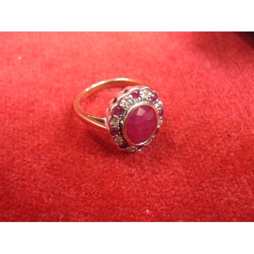 28 - 9ct YELLOW AND WHITE GOLD CLUSTER RING SET WITH AN OVAL CUT RUBY APPROX 3.27ct AND SET WITH 8 ROUND ... 