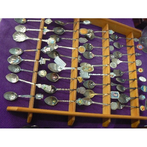 111 - LARGE COLLECTION OF SOUVENIR SPOONS DISPLAYED ON 2 WOODEN WALL RACKS.