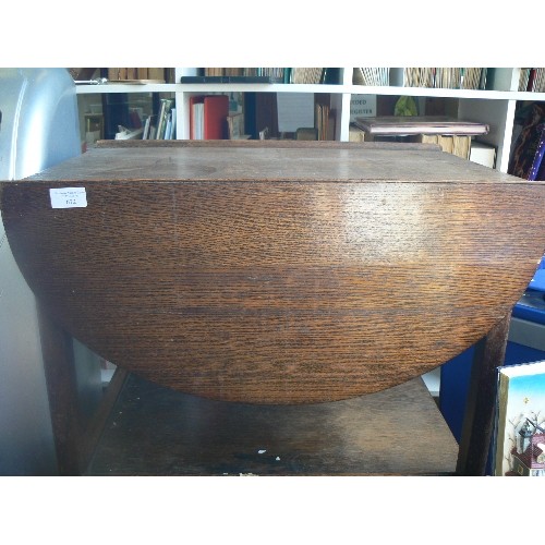 672 - VINTAGE DROP LEAF TEA TROLLEY ON CASTORS. CREATES AN OVAL TABLE TOP WHEN OPENED UP. BOTTOM SHELF.