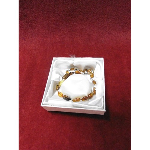 82 - 2 AMBER BRACELETS 1 WITH SOLID SILVER THE OTHER MORE ETHNIC RAW AMBER OF DIFFERENT COLOURS