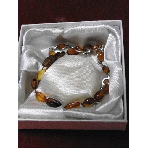 82 - 2 AMBER BRACELETS 1 WITH SOLID SILVER THE OTHER MORE ETHNIC RAW AMBER OF DIFFERENT COLOURS