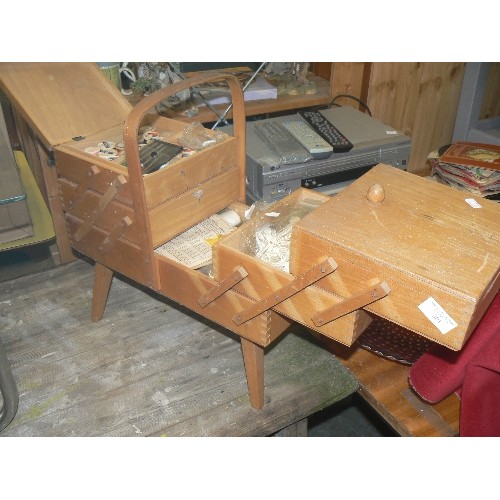 301 - WOODEN CANTILEVER SEWING BOX ON RAISED LEGS. FULL OF SEWING CONTENTS.