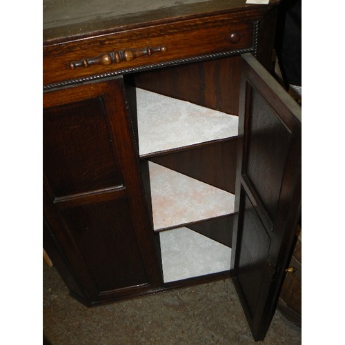 295 - VINTAGE DARK OAK CORNER CUPBOARD WITH TWISTED ROPE BEADING. DOUBLE PANELLED DOORS AND DROP HANDLE.