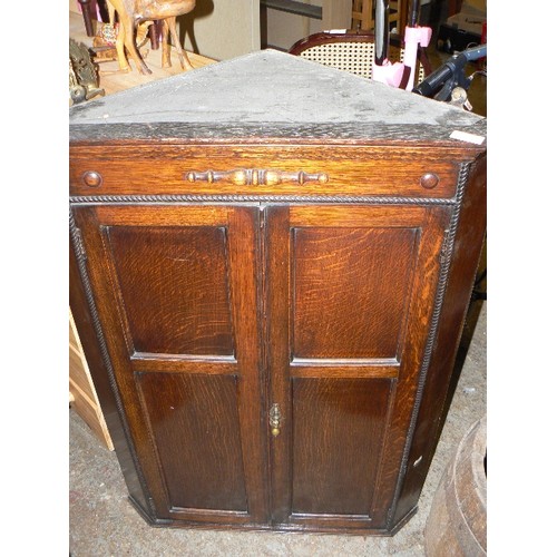 295 - VINTAGE DARK OAK CORNER CUPBOARD WITH TWISTED ROPE BEADING. DOUBLE PANELLED DOORS AND DROP HANDLE.