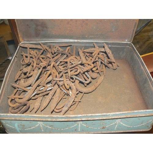 215 - CAST IRON TRIVET, EGG RACK, BOX OF DOUBLE-ENDED NAILS, ALL CONTAINED IN A VINTAGE WIRE BASKET.