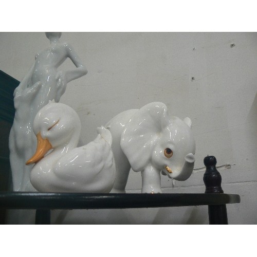 338 - WHITE PORCELAIN ORNAMENTS, A DECO STYLE FIGURE, AN ELEGANT LADY, AN ELEPHANT AND A DUCK.