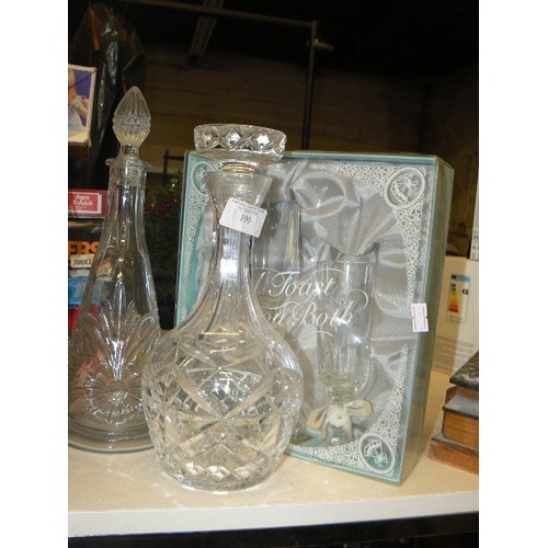 190 - 2 GLASS DECANTERS WITH STOPPERS, TOGETHER WITH SILVER WEDDING FLUTES GIFT-SET. APPEARS NEW.