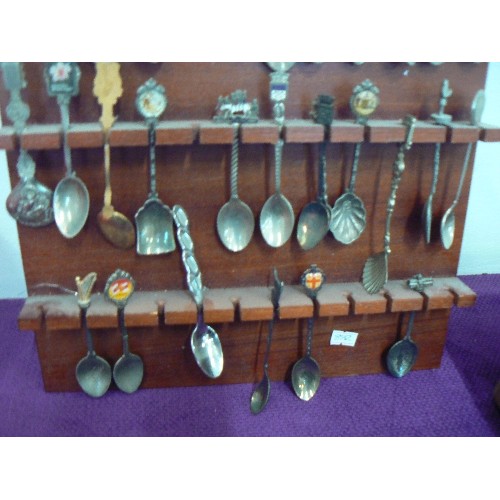 125 - LARGE COLLECTION OF SOUVENIR SPOONS DISPLAYED ON WOODEN WALL RACK.