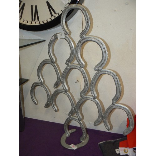 130 - LARGE HORSESHOE DISPLAY MADE FROM SILVER-PAINTED HORSESHOES.