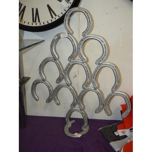 130 - LARGE HORSESHOE DISPLAY MADE FROM SILVER-PAINTED HORSESHOES.