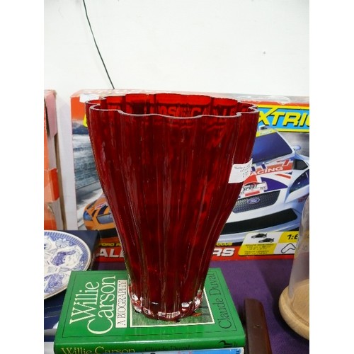 133 - LARGE HEAVY RED GLASS VASE PLUS TALL GREEN GLASS VASE.