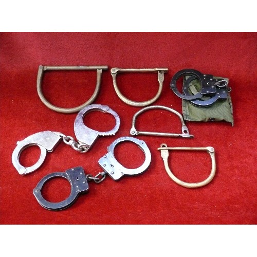 292D - Collection of antique and vintage handcuffs and shackles. A pair of american handcuffs with key in a... 