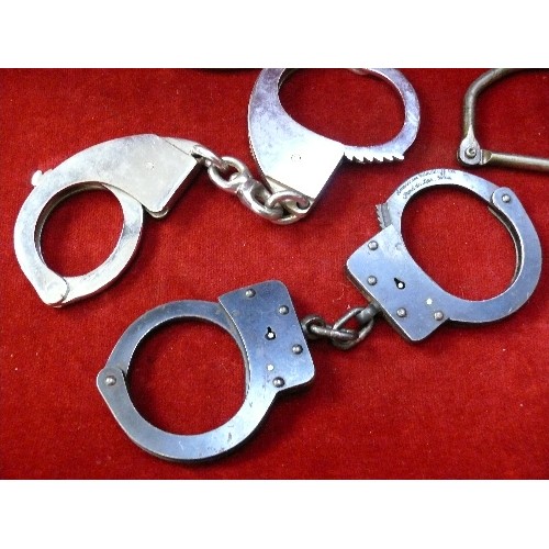 292D - Collection of antique and vintage handcuffs and shackles. A pair of american handcuffs with key in a... 