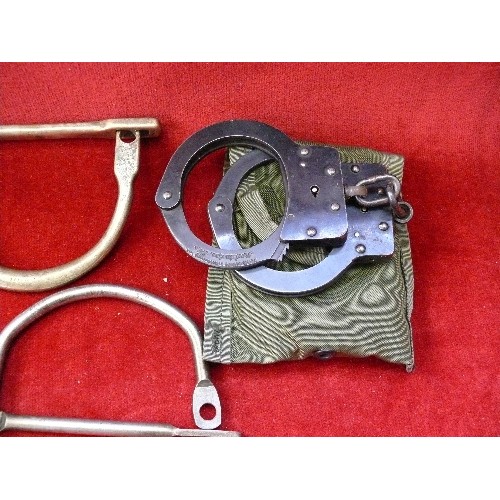 292D - Collection of antique and vintage handcuffs and shackles. A pair of american handcuffs with key in a... 