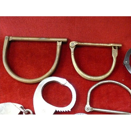 292D - Collection of antique and vintage handcuffs and shackles. A pair of american handcuffs with key in a... 