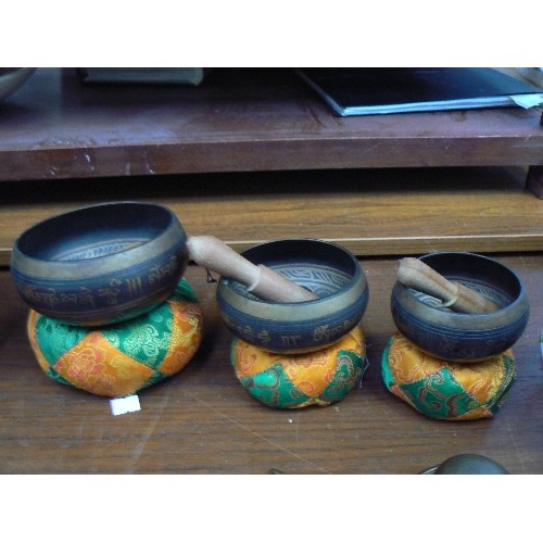 5 - A good 20th Century graduated set of Tibetan patinated brass singing bowls with cushions and mallets... 