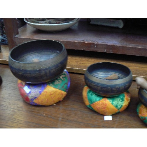 5 - A good 20th Century graduated set of Tibetan patinated brass singing bowls with cushions and mallets... 