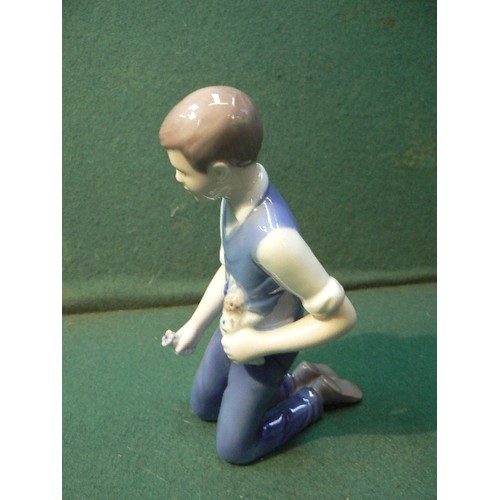 113 - A late 20th Century Danish Porcelain figure of a young man kneeling, with flowers, by Bing & Grondah... 